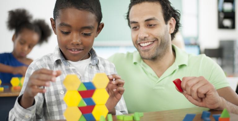 Education professional with young student employing block-based math strategies